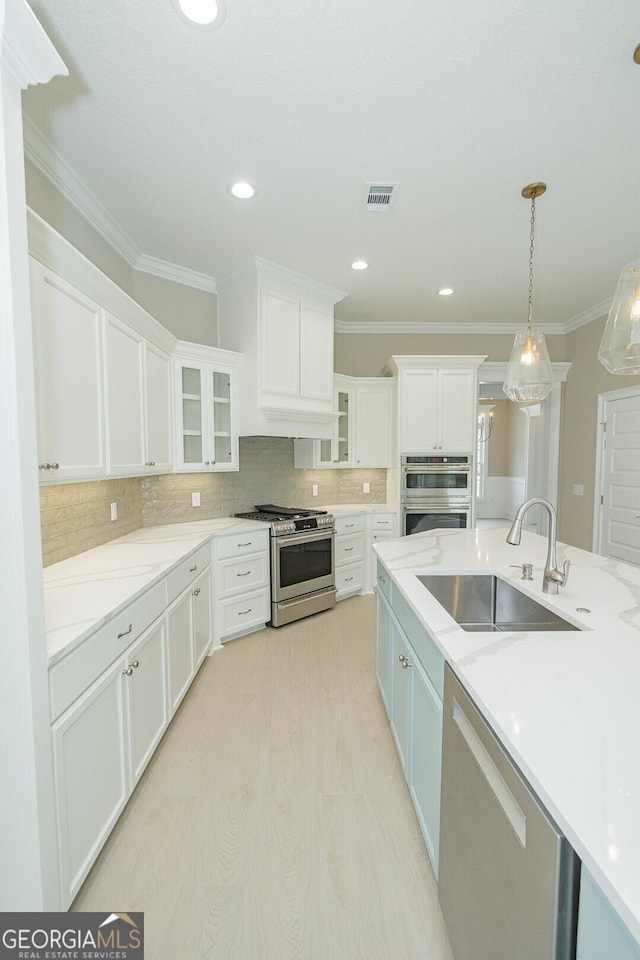 215 Jake Colton Dr, Kingsland, GA 31548 - kitchen featuring appliances with stainless steel finishes, a sink, white cabinets, ornamental molding, and backsplash