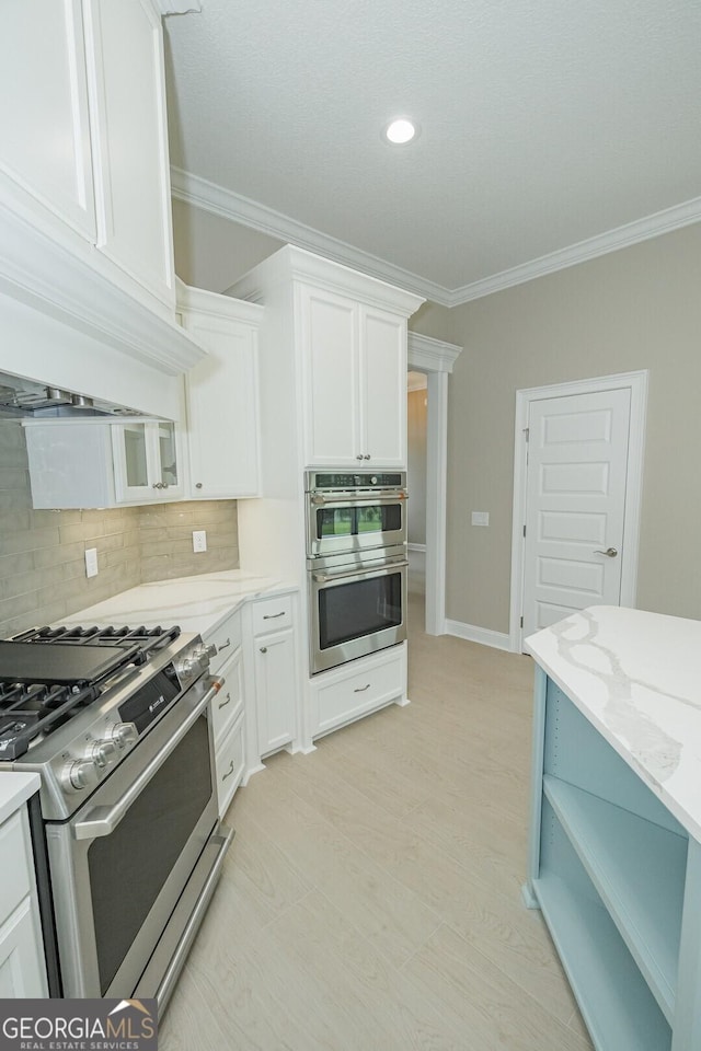 215 Jake Colton Dr, Kingsland, GA 31548 - kitchen featuring stainless steel appliances, crown molding, white cabinets, tasteful backsplash, and light stone countertops