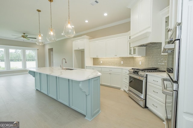 215 Jake Colton Dr, Kingsland, GA 31548 - kitchen featuring a sink, stainless steel range with gas stovetop, decorative backsplash, a ceiling fan, and white cabinetry