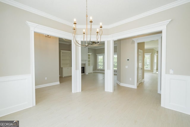 215 Jake Colton Dr, Kingsland, GA 31548 - unfurnished dining area featuring a chandelier, crown molding, a fireplace, light wood finished floors, and wainscoting