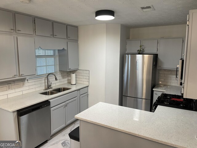401 Bainbridge Dr, Mcdonough, GA 30253 - kitchen with stainless steel appliances, gray cabinetry, a sink, and a textured ceiling
