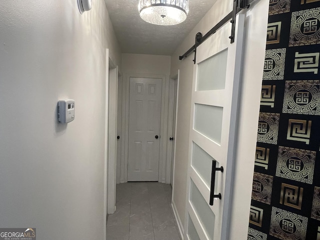 401 Bainbridge Dr, Mcdonough, GA 30253 - hallway featuring a barn door, a textured ceiling, and baseboards