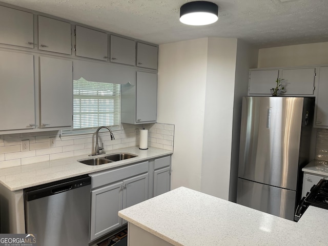 401 Bainbridge Dr, Mcdonough, GA 30253 - kitchen with appliances with stainless steel finishes, a sink, gray cabinetry, a textured ceiling, and decorative backsplash