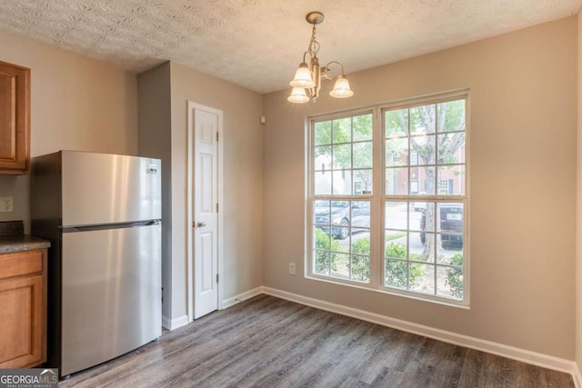 1851 Grove Way, Hampton, GA 30228 - kitchen featuring freestanding refrigerator, wood finished floors, brown cabinets, a chandelier, and a textured ceiling