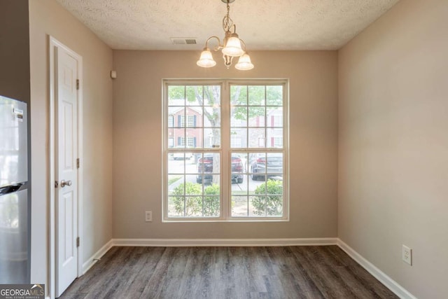 1851 Grove Way, Hampton, GA 30228 - unfurnished dining area featuring a chandelier, a textured ceiling, and dark wood-type flooring