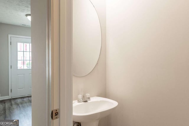 1851 Grove Way, Hampton, GA 30228 - bathroom featuring a textured ceiling and wood finished floors