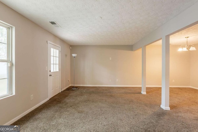 1851 Grove Way, Hampton, GA 30228 - unfurnished living room featuring a textured ceiling, carpet flooring, and a chandelier