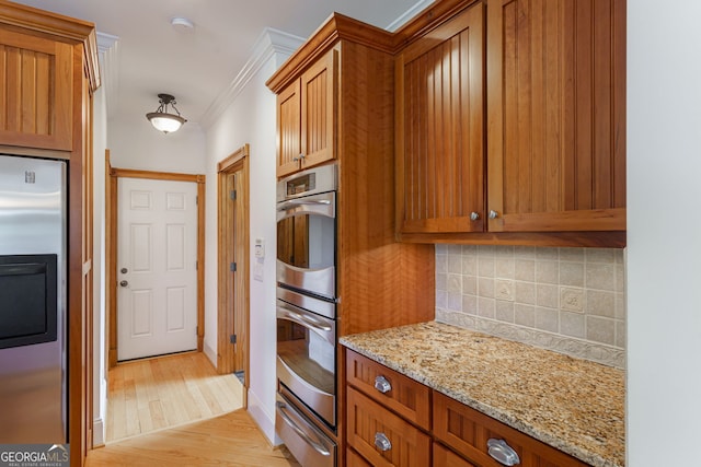 4320 Sandy Creek Rd, Madison, GA 30650 - kitchen featuring appliances with stainless steel finishes, a warming drawer, tasteful backsplash, brown cabinets, and ornamental molding