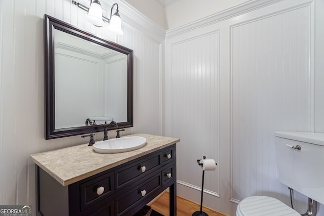 4320 Sandy Creek Rd, Madison, GA 30650 - bathroom with toilet, vanity, wood finished floors, and a decorative wall
