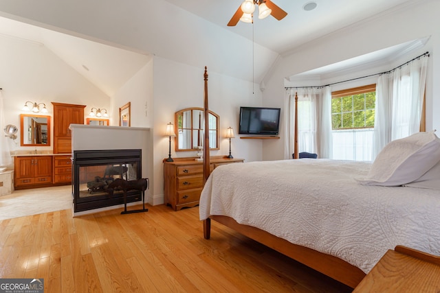 4320 Sandy Creek Rd, Madison, GA 30650 - bedroom with lofted ceiling, light wood-style flooring, a multi sided fireplace, ceiling fan, and ensuite bathroom