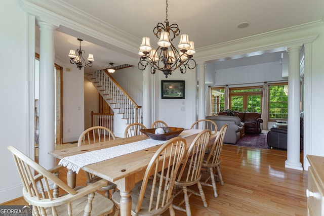 4320 Sandy Creek Rd, Madison, GA 30650 - dining room with light wood finished floors, a chandelier, crown molding, stairs, and ornate columns