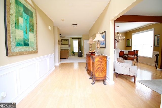 318 Ivy Manor Dr, Marietta, GA 30064 - corridor featuring healthy amount of natural light, wood finished floors, a chandelier, wainscoting, and a decorative wall