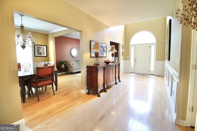 318 Ivy Manor Dr, Marietta, GA 30064 - entryway featuring a chandelier, light wood-style floors, wainscoting, crown molding, and a decorative wall