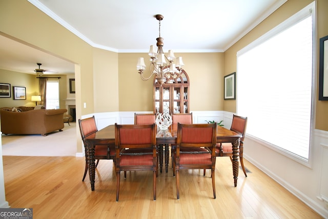 318 Ivy Manor Dr, Marietta, GA 30064 - dining area with a chandelier, light wood finished floors, crown molding, wainscoting, and a fireplace