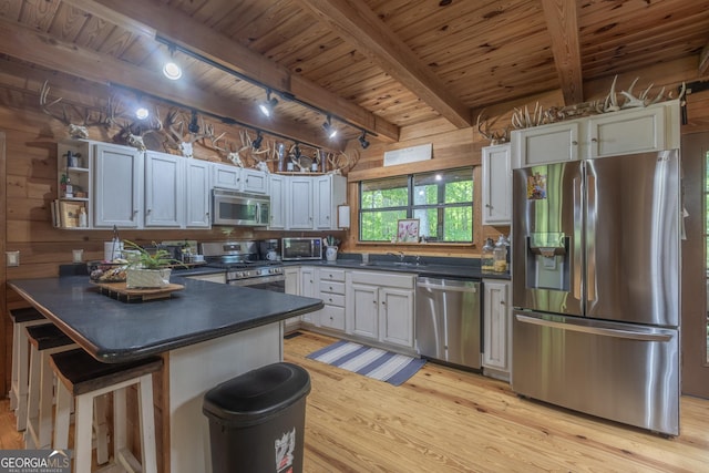 912 Folds Rd, Carrollton, GA 30116 - kitchen with stainless steel appliances, track lighting, wood ceiling with exposed beams, dark countertops, and light wood-style flooring