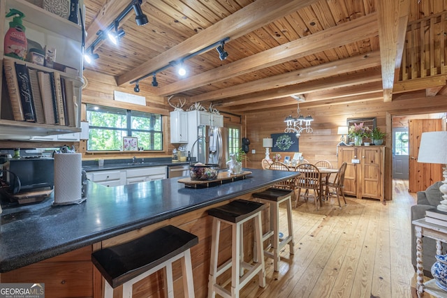 912 Folds Rd, Carrollton, GA 30116 - kitchen featuring dark countertops, wood walls, track lighting, wood ceiling with exposed beams, and stainless steel appliances