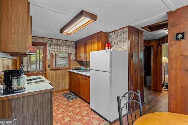 8378 Dillard Rd, Scaly, NC 28775 - kitchen featuring freestanding refrigerator, wood walls, light countertops, brown cabinets, and a sink