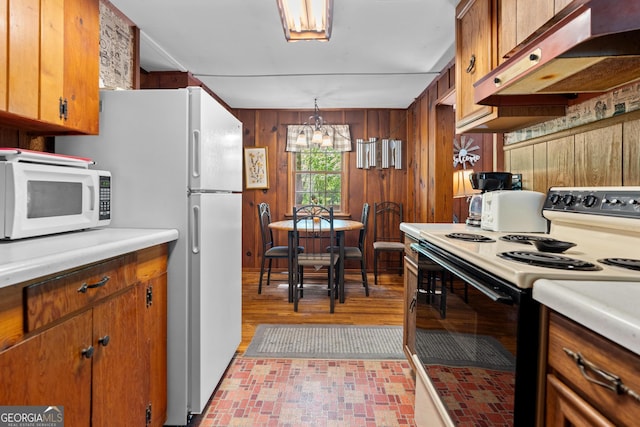 8378 Dillard Rd, Scaly, NC 28775 - kitchen with electric range oven, white microwave, under cabinet range hood, a chandelier, and brick patterned flooring