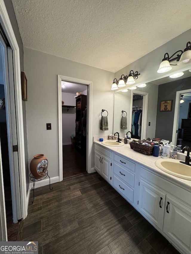 281 Cambridge Cir, Kingsland, GA 31548 - full bath featuring a walk in closet, double vanity, a textured ceiling, and wood finished floors