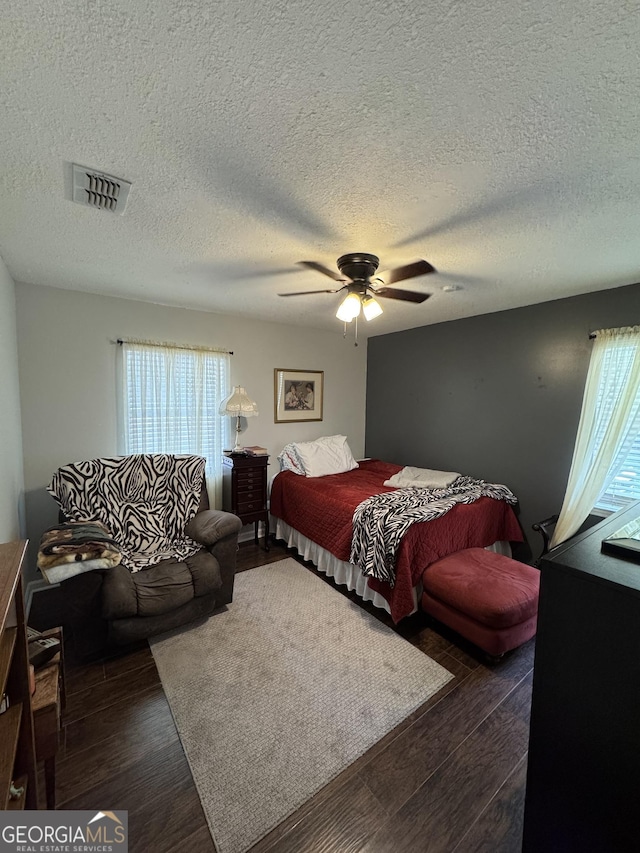 281 Cambridge Cir, Kingsland, GA 31548 - bedroom with multiple windows, dark wood-style flooring, a textured ceiling, and ceiling fan