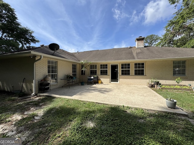 281 Cambridge Cir, Kingsland, GA 31548 - rear view of house featuring brick siding, a chimney, and a patio area