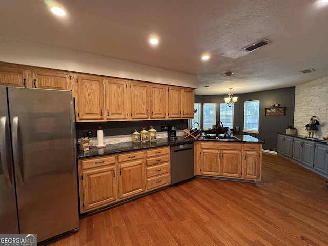281 Cambridge Cir, Kingsland, GA 31548 - kitchen featuring appliances with stainless steel finishes, dark countertops, a peninsula, dark wood-type flooring, and recessed lighting
