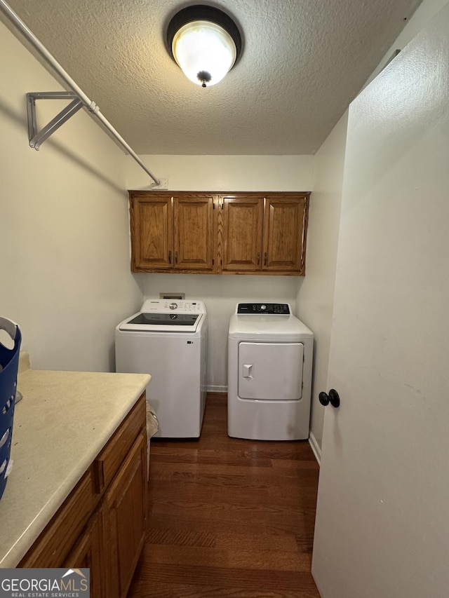281 Cambridge Cir, Kingsland, GA 31548 - washroom featuring cabinet space, washer and dryer, dark wood-style flooring, and a textured ceiling