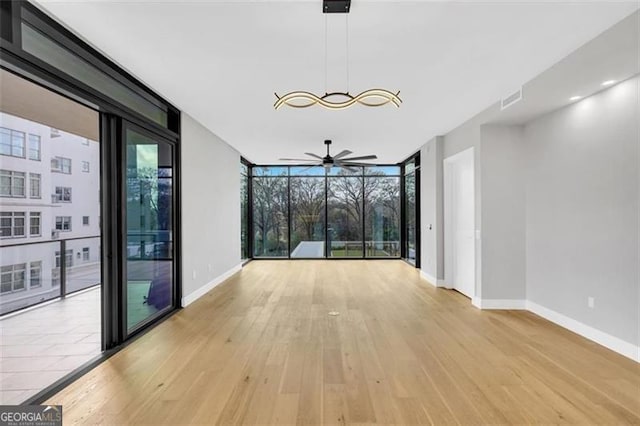 2520 Peachtree Rd Unit 403, Atlanta, GA 30305 - spare room with a wall of windows, a ceiling fan, baseboards, and light wood-style flooring