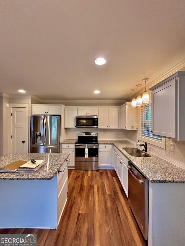 523 Huntleigh Dr, Winder, GA 30680 - kitchen with appliances with stainless steel finishes, a sink, dark wood finished floors, light stone countertops, and recessed lighting