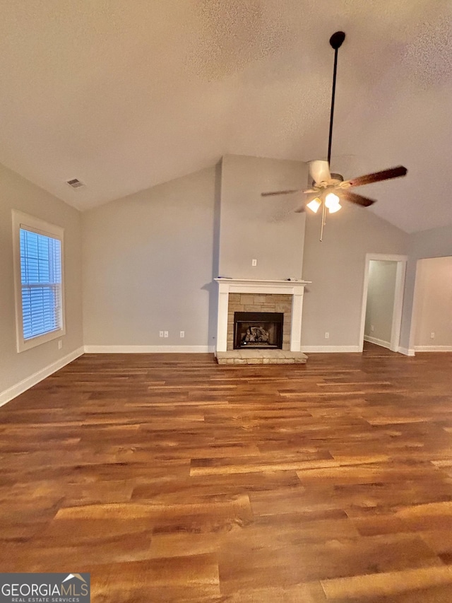 523 Huntleigh Dr, Winder, GA 30680 - unfurnished living room featuring lofted ceiling, ceiling fan, wood finished floors, baseboards, and a fireplace with raised hearth