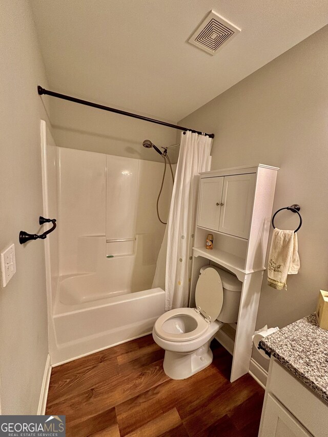 523 Huntleigh Dr, Winder, GA 30680 - bathroom with toilet, wood finished floors, vanity, shower / bathtub combination with curtain, and baseboards