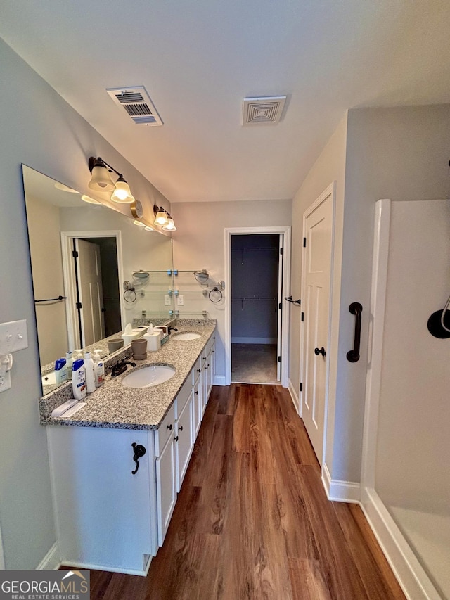 523 Huntleigh Dr, Winder, GA 30680 - bathroom with wood finished floors, double vanity, and baseboards