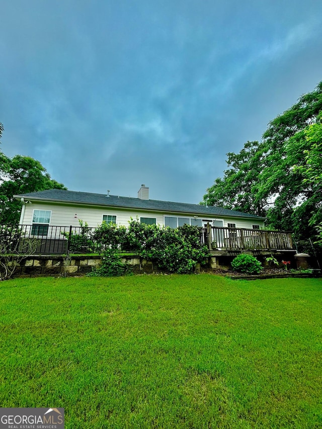 523 Huntleigh Dr, Winder, GA 30680 - rear view of property featuring a wooden deck, a yard, and a chimney