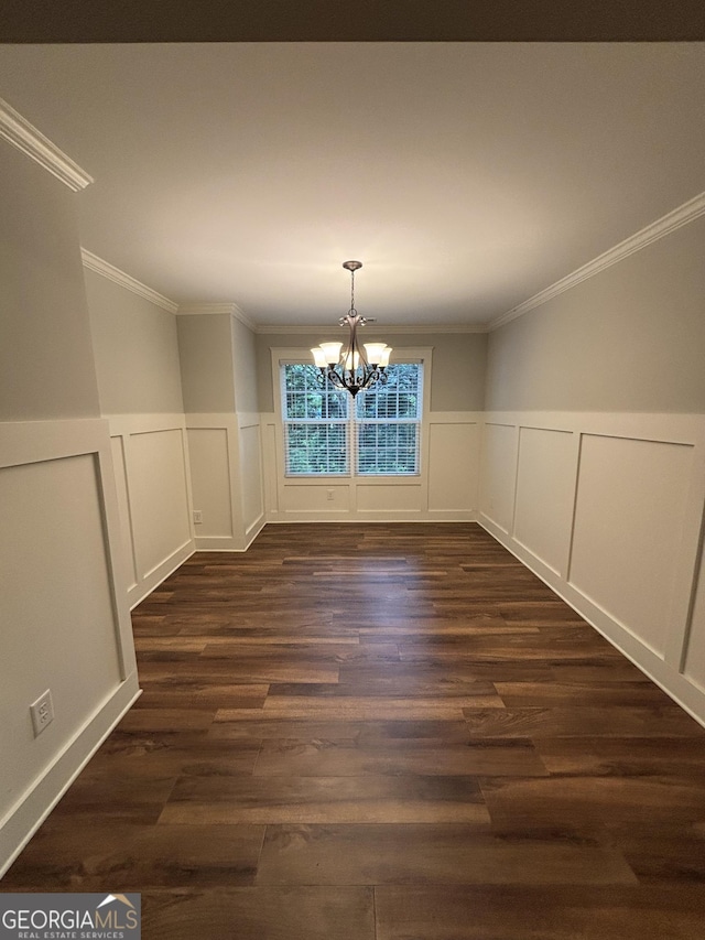 523 Huntleigh Dr, Winder, GA 30680 - unfurnished dining area featuring a chandelier, crown molding, a decorative wall, dark wood-style floors, and a wainscoted wall