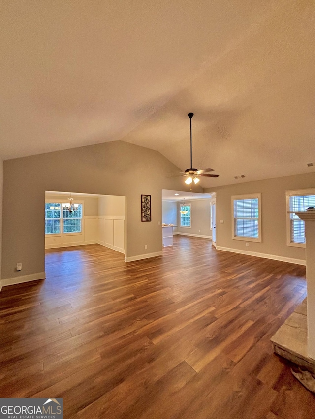 523 Huntleigh Dr, Winder, GA 30680 - unfurnished living room with a chandelier, dark wood-style floors, baseboards, vaulted ceiling, and a ceiling fan