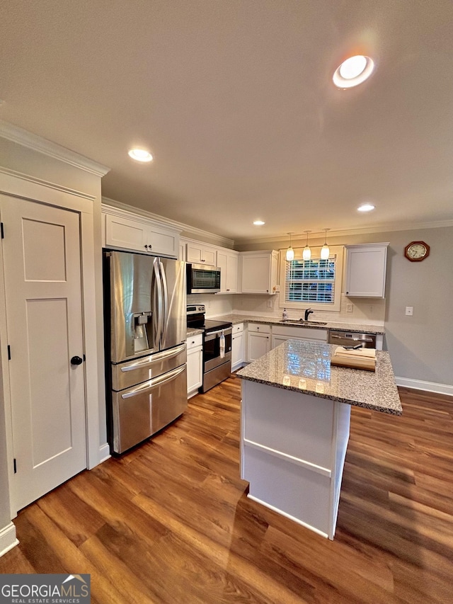 523 Huntleigh Dr, Winder, GA 30680 - kitchen with stainless steel appliances, ornamental molding, a sink, a kitchen island, and white cabinets
