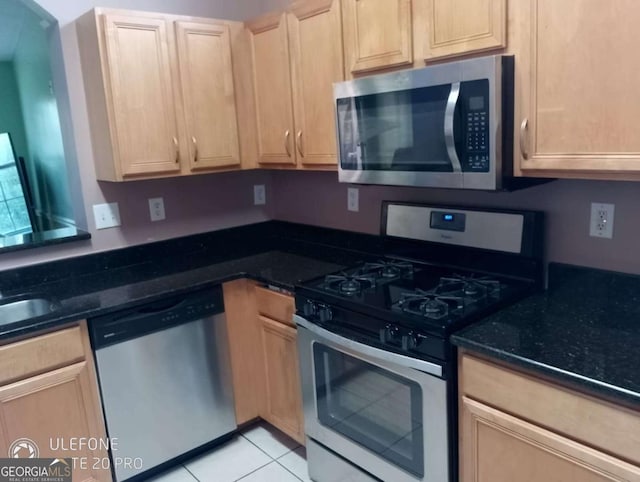 2918 Egret Ln, Austell, GA 30106 - kitchen featuring stainless steel appliances, light brown cabinets, dark stone counters, and light tile patterned floors