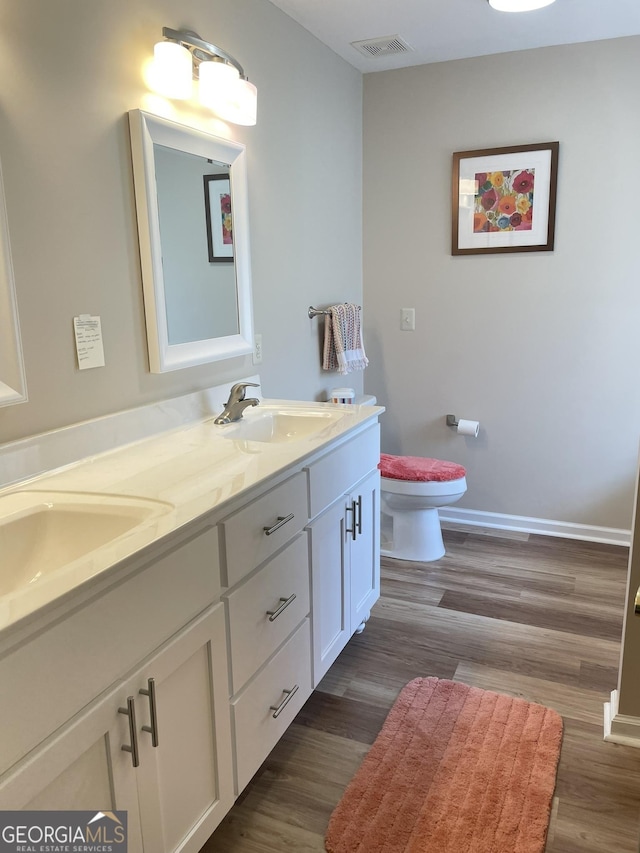 205 Ellicott Dr, Warner Robins, GA 31088 - full bathroom with double vanity, toilet, wood finished floors, and baseboards