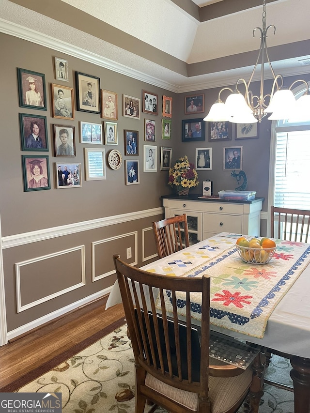 205 Ellicott Dr, Warner Robins, GA 31088 - dining area with a chandelier, wood finished floors, ornamental molding, a wainscoted wall, and a decorative wall