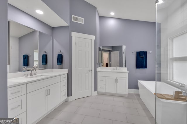 510 Watergate Ct, Roswell, GA 30076 - bathroom featuring a freestanding bath, two vanities, and tile patterned floors