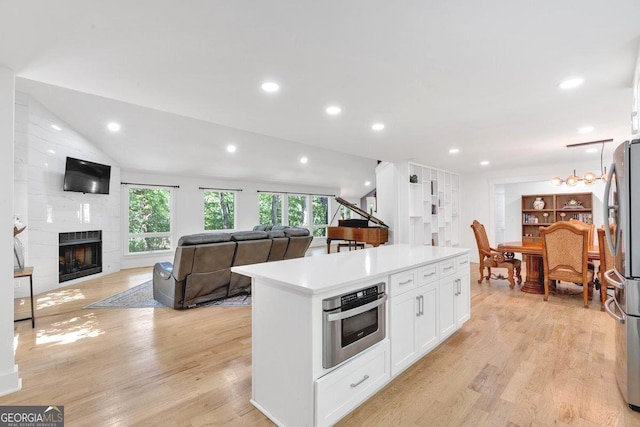 510 Watergate Ct, Roswell, GA 30076 - kitchen with appliances with stainless steel finishes, white cabinets, light wood-type flooring, a center island, and light countertops