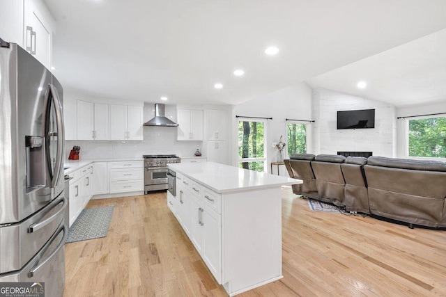 510 Watergate Ct, Roswell, GA 30076 - kitchen with stainless steel appliances, wall chimney range hood, open floor plan, lofted ceiling, and light wood-style flooring