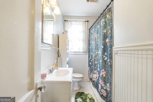 331 Corbin Ave, Macon, GA 31204 - bathroom with toilet, tile patterned floors, vanity, a wainscoted wall, and curtained shower