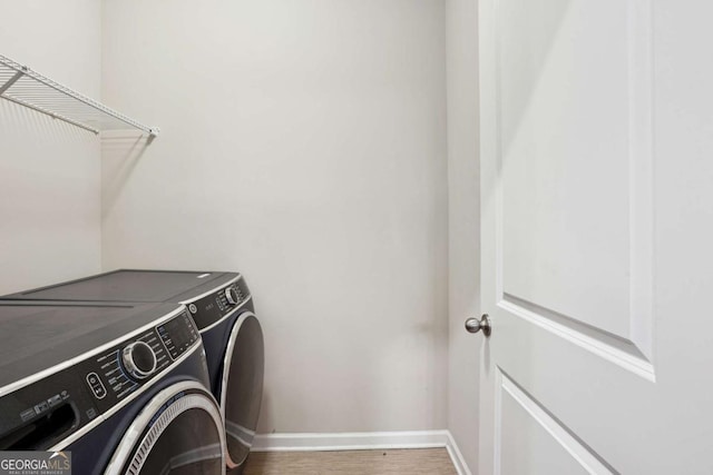 106 Logan Pass Dr, Loganville, GA 30052 - laundry room featuring washer and dryer, baseboards, and wood finished floors