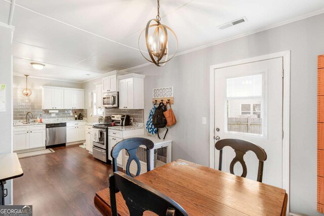632 Lawson St, Bremen, GA 30110 - dining room featuring a chandelier, dark wood-style flooring, and crown molding