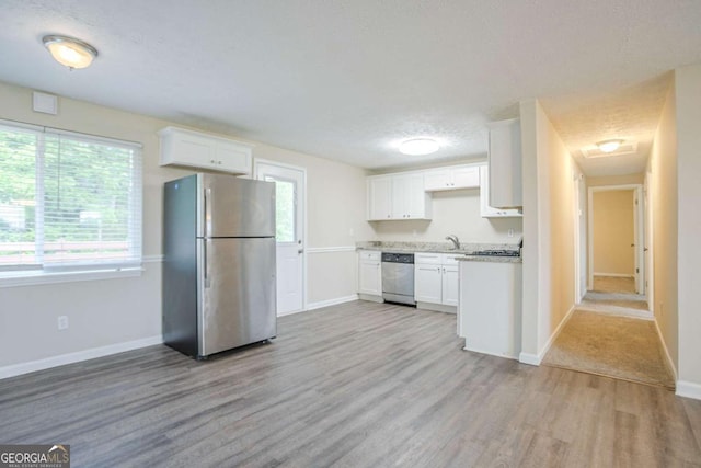 2290 Pope Rd, Douglasville, GA 30135 - kitchen with stainless steel appliances, light wood finished floors, white cabinetry, light countertops, and healthy amount of natural light