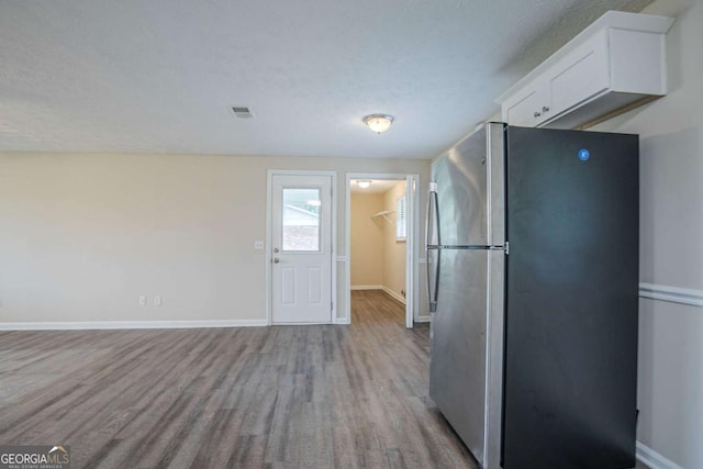 2290 Pope Rd, Douglasville, GA 30135 - kitchen with freestanding refrigerator, wood finished floors, white cabinets, and a textured ceiling