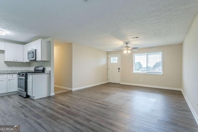 2290 Pope Rd, Douglasville, GA 30135 - kitchen featuring appliances with stainless steel finishes, a textured ceiling, a ceiling fan, dark wood-style flooring, and white cabinets