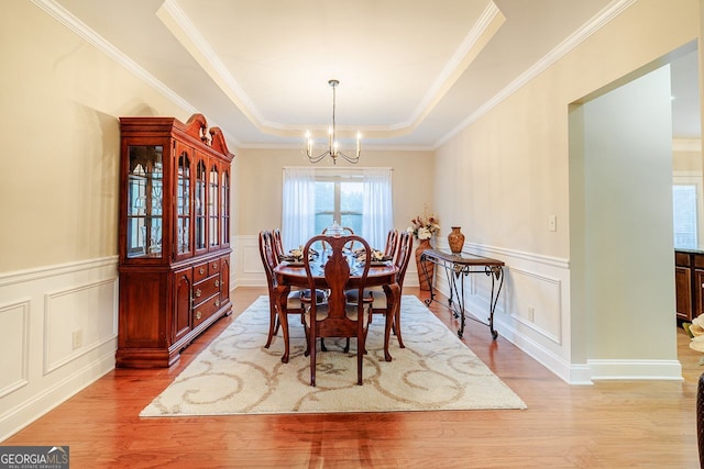 3623 Terrah Point Dr, Duluth, GA 30097 - dining room featuring a decorative wall, a chandelier, ornamental molding, a tray ceiling, and light wood-type flooring