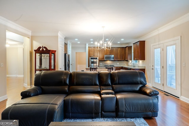 3623 Terrah Point Dr, Duluth, GA 30097 - living room with a chandelier, light wood-style floors, crown molding, baseboards, and recessed lighting